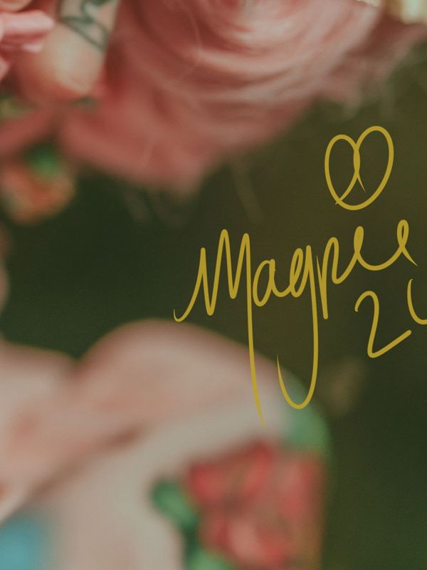 Close up of the lower right corner: pink blossoms and dark petals with the Magpie signature in gold script.
