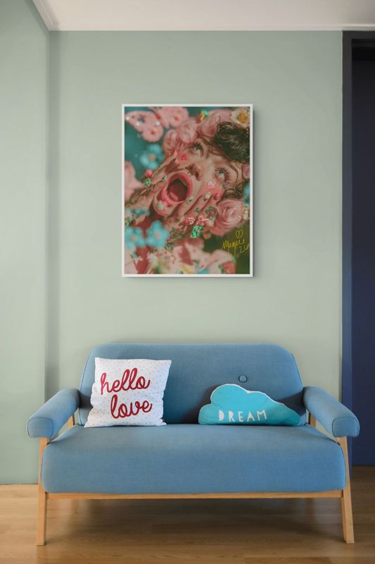 The screaming flowers print hung above a blue mid century loveseat with a hello love cushion on a pale green wall.