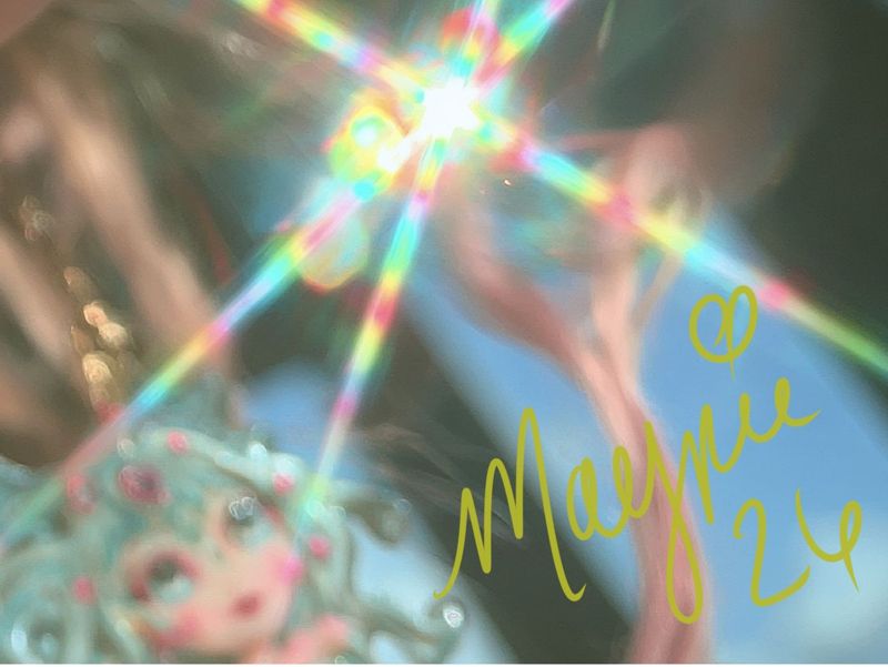 Close up of the lower right corner: rainbow bokeh and light flare with the Magpie signature in gold script.