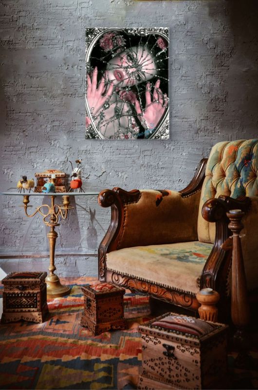 The shattered mirror print on a textured grey brick wall above an ornate carved antique sofa, a brass candle stand and carved wooden chests on a patterned rug.