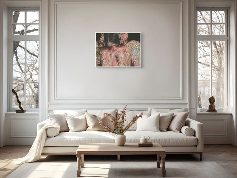 The weeping angel doll print hung on a white paneled wall above a cream sofa between tall windows.