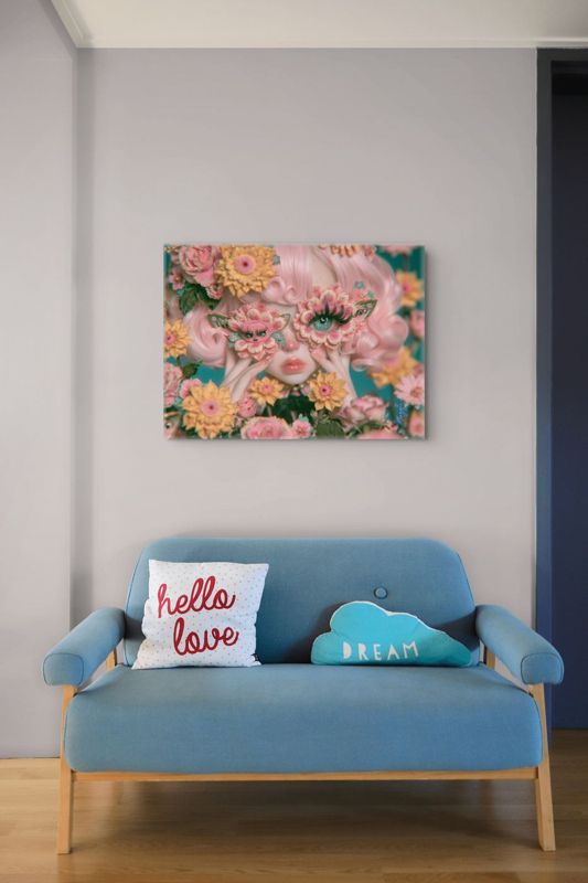 Landscape art print of a surreal butterfly floral mask portrait above a blue mid-century loveseat with a 'hello love' pillow and teal cloud-shaped 'DREAM' pillow.