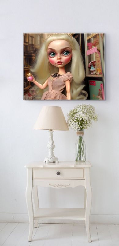 The blonde doll with perfume canvas hung on a white wall above a cream bedside table with a lamp and a vase of baby's breath.