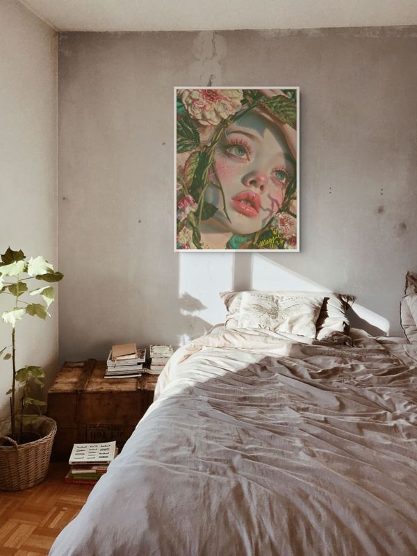 The girl in the vines print hung on a raw plaster wall above a low bed with grey linen in a loft.