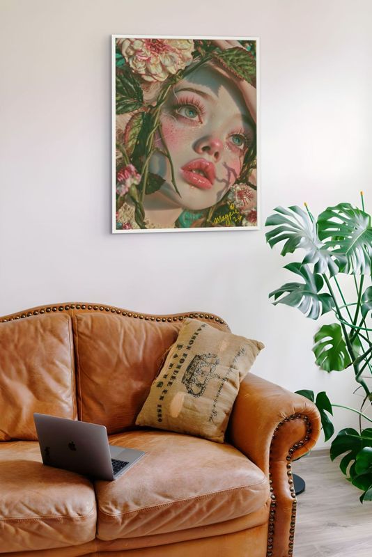 The girl in the vines print hung above a tan leather armchair with a large plant beside a window.