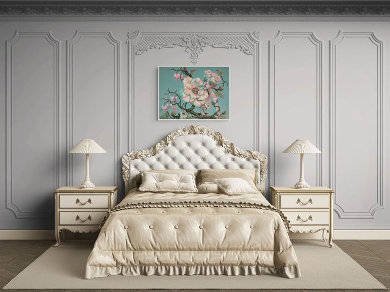 The flower doll on a branch print hung on a white paneled wall above a tufted cream bed with matching nightstands.
