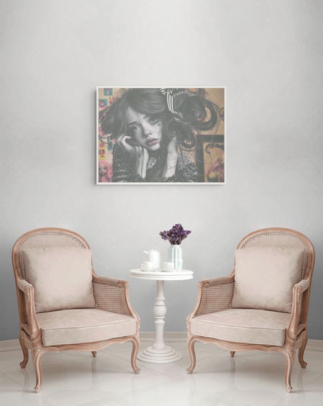 The black and white girl print hung on a pale wall above two blush cane armchairs and a small white tea table with lilacs.