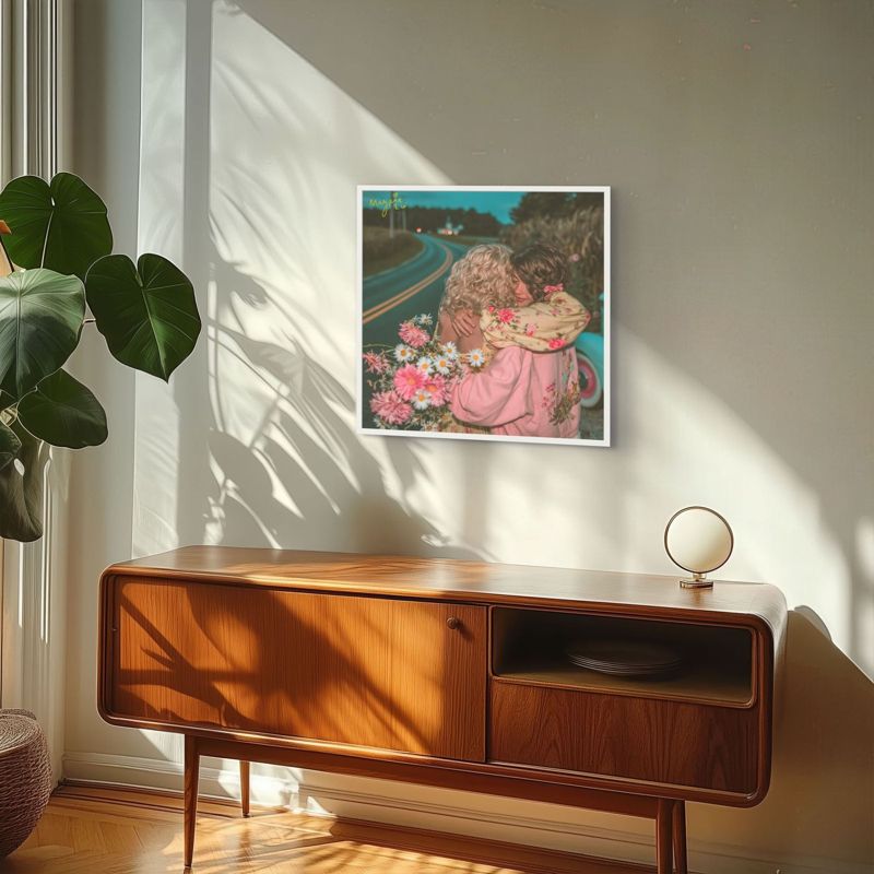 The roadside hug print hung on a pale wall above a mid century wooden sideboard in warm window light with a large plant.